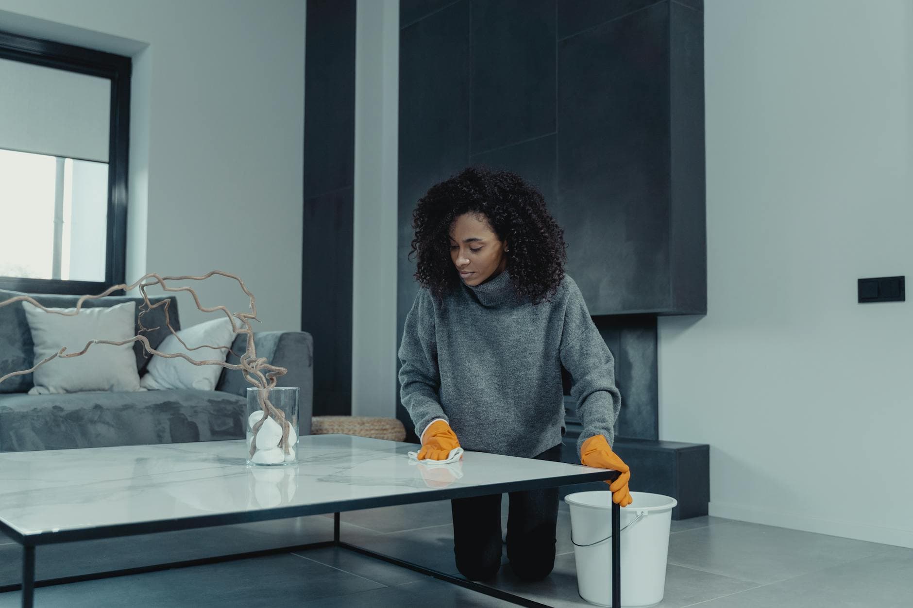 Professional house cleaner wiping a table in a contemporary New York apartment — cleaning services in Great Neck, Nassau County